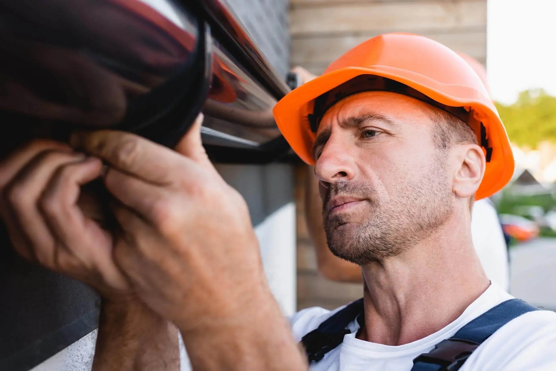 Gutter installer working on a home's rain gutter